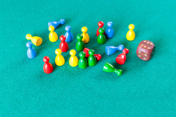 istock wooden dice and multicolored board game pawns 1142442105