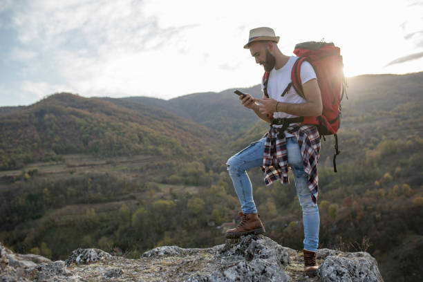 istock Hiker using phone on the top of the hill 1142443648