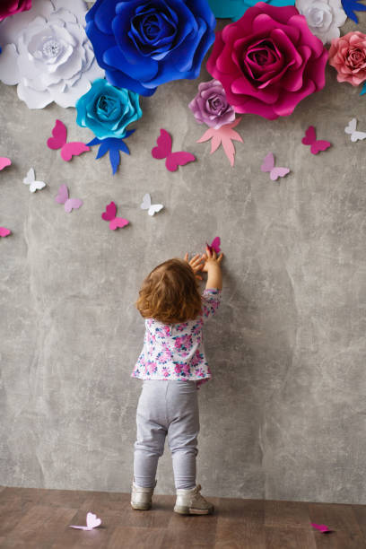 Little girl playing with paper butterfly