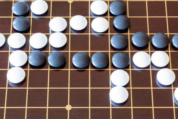 istock gameplay of Go game on wooden board 1142446012