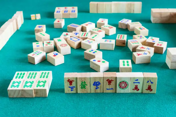side view of gameboard of mahjong game, tile-based chinese strategy board game on green baize table