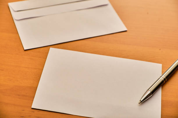 istock Paper, modern envelope and metal ballpoint on wooden table 1142450946