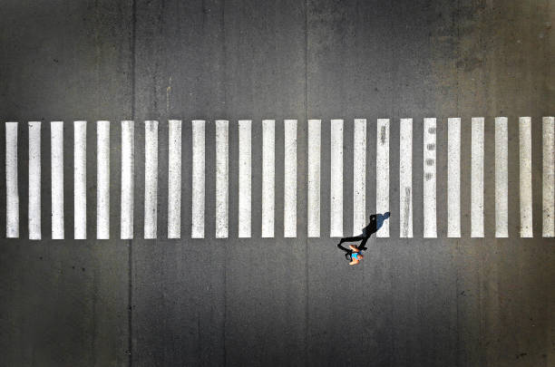 Pedestrian crosswalk with one footpassenger, aerial, top view Aerial view of a pedestrian crosswalk with one footpassenger crossing stock pictures, royalty-free photos & images