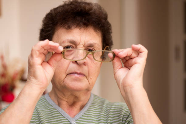 istock Senior woman is putting on glasses. 1142451130