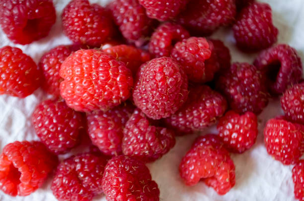 istock Big ripe raspberries are laying on the  table covered with white tablecloth 1142451241