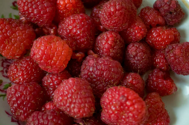 istock Big ripe raspberries are laying on the  table covered with white tablecloth 1142451333