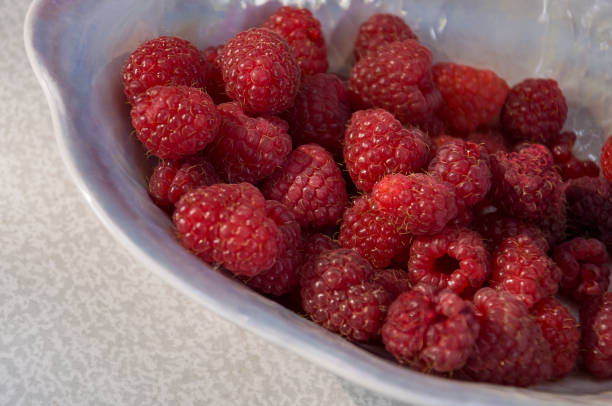 istock Big ripe raspberries are laying on the  table covered with white tablecloth 1142451456