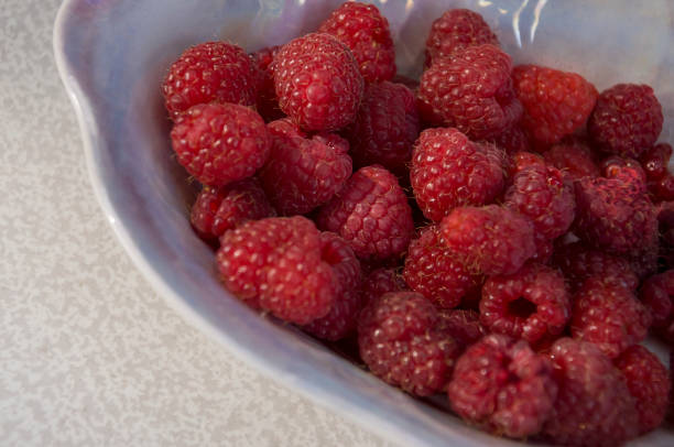 istock Big ripe raspberries are laying on the  table covered with white tablecloth 1142451457