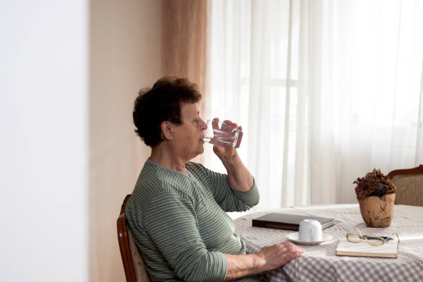istock Elderly woman relaxing at home with drink 1142451983