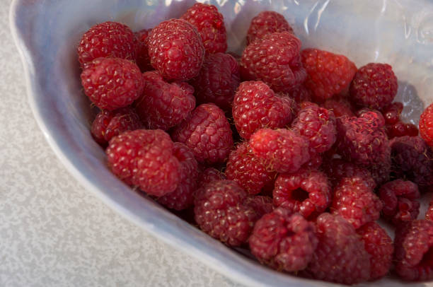 istock Big ripe raspberries are laying on the  table covered with white tablecloth 1142452001