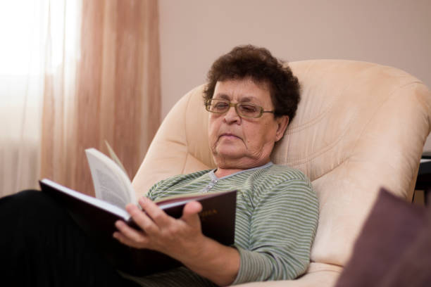 istock Elder woman reading a book at home. 1142452736