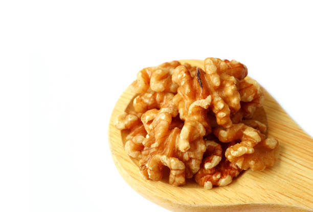 istock Closed up Raw Walnut Kernels on Wooden Ladle Isolated on White Background 1142454558