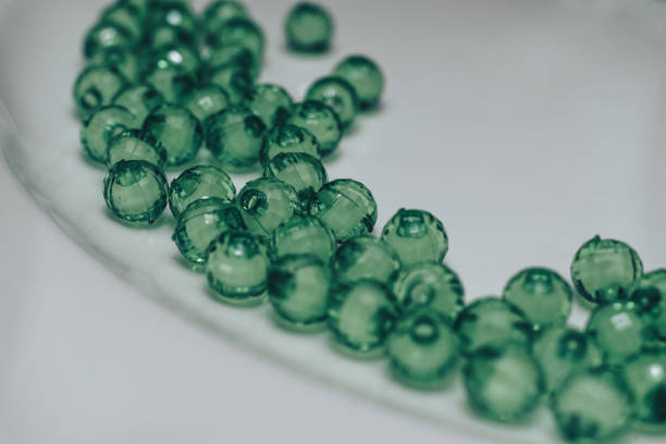 Green glass beads on a white background. Macro view.