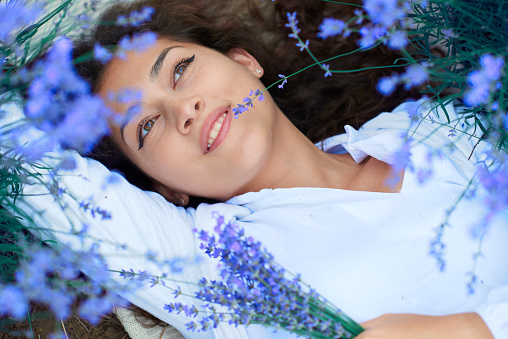 young woman lies in the lavender flower field, beautiful summer landscape