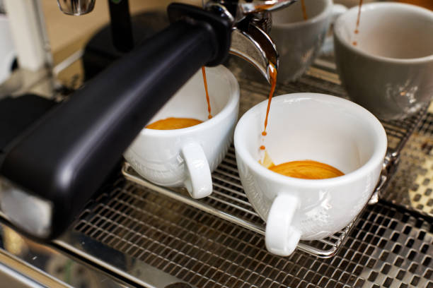 istock Coffee brewing in coffee machine. Espresso pouring in two cups. 1142470489