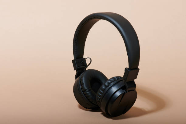 istock Black headphones on beige color background 1142472112