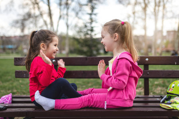 istock Beautiful playful siblings on a bench at a park having fun 1142472357