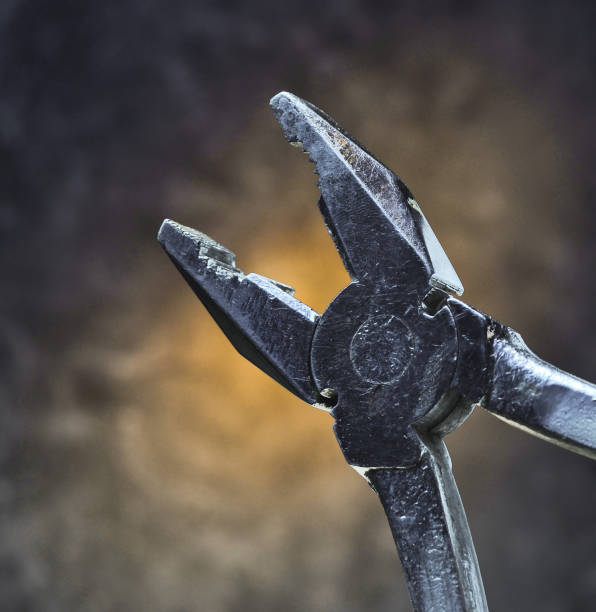 istock Work tool pliers against the background of the concrete wall. Mystical red light. 1142472550