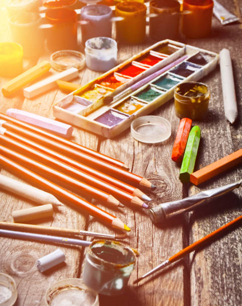 istock Tools for the artist. Inspiration to create. Objects for drawing. Paint, crayons, pencils on a wooden table. 1142473700