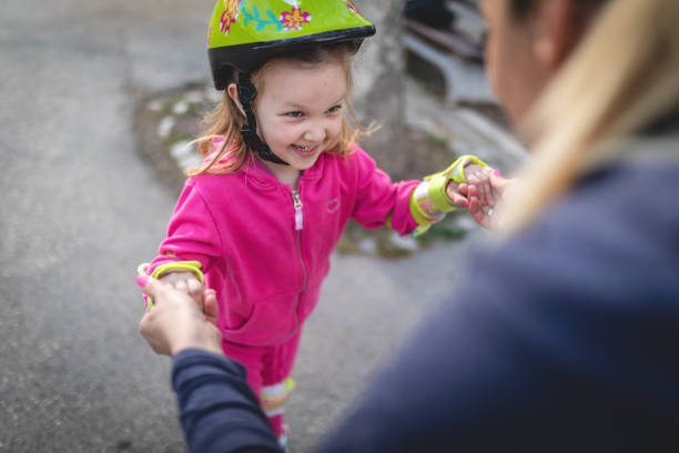istock Mother teaching daughter how to ride rollerblades 1142474012