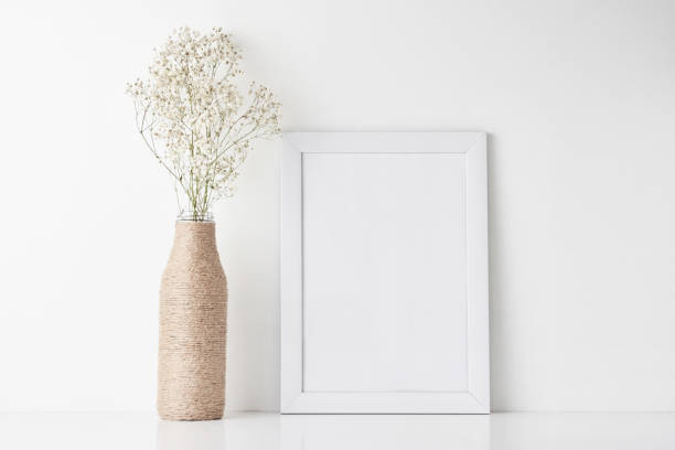 istock Workspace desk with empty frame and flower in vase 1142479279