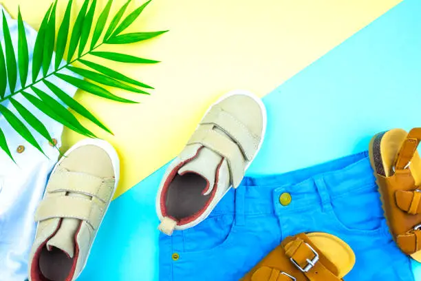 Photo of Sneakers and sandals on a trendy color background, top view, summer shoes.