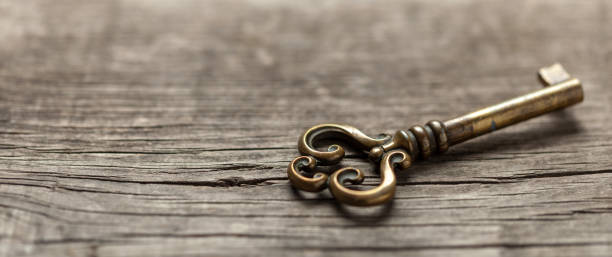 istock Old copper key on wooden table. Copy space for text. 1142480395