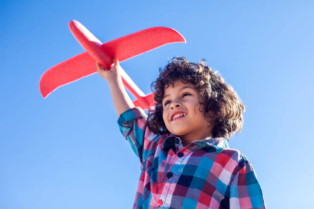 istock Young happy boy playing with red airplane outdoor 1142487201