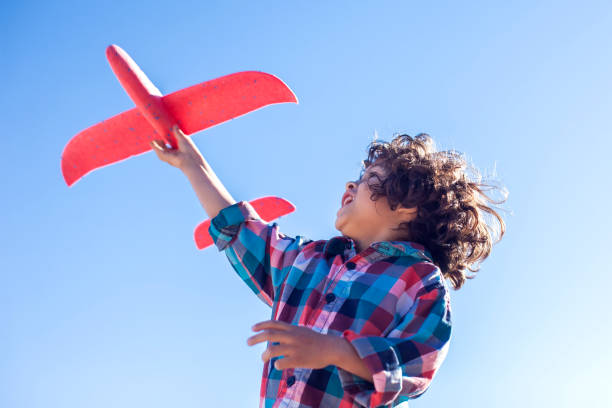 istock Young happy boy playing with red airplane outdoor 1142487210