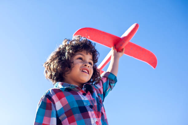 istock Young happy boy playing with red airplane outdoor 1142487214