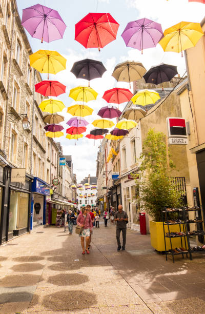 people walk along the pedestrian shopping street under the umbrellas of cherbourg. normandy france - cherbourg imagens e fotografias de stock