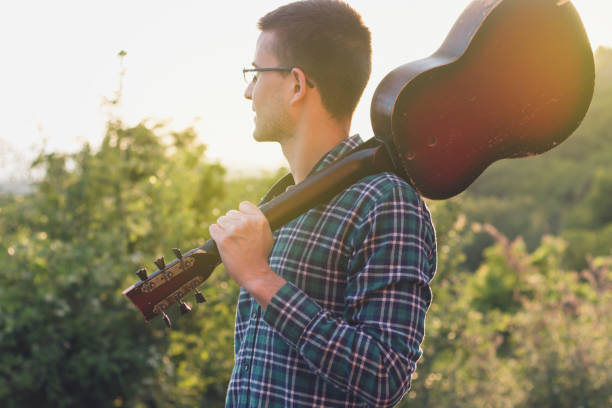 istock Hipster Musician with an Old Guitar 1142490335