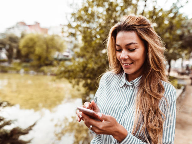 istock woman checking the phone outdoor 1142492443
