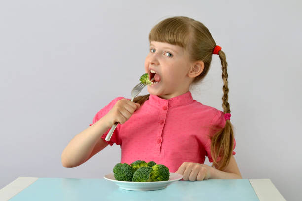 istock child, kid (little girl) loves broccoli. 1142492965
