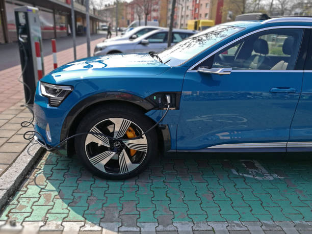 Charging an electric car - AUDI e-tron Fuerth, Germany - April 13, 2019: A red AUDI e-tron electric drive car is being charged on a charging station on a sunny day. fuerth stock pictures, royalty-free photos & images