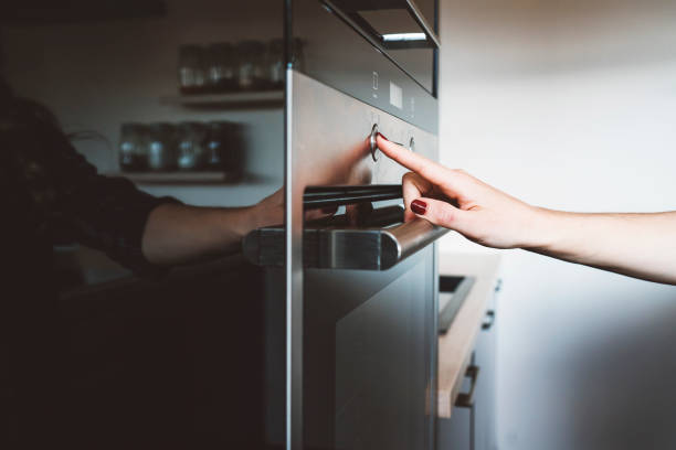 istock A close up of an index finger pressing a button on the oven 1142493666