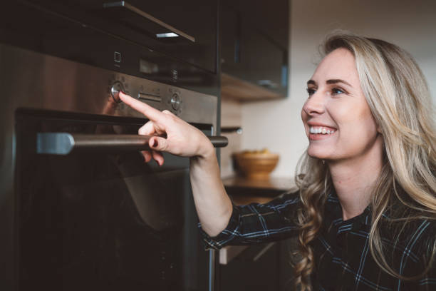 istock A happy girl pressing a button on an oven 1142493825