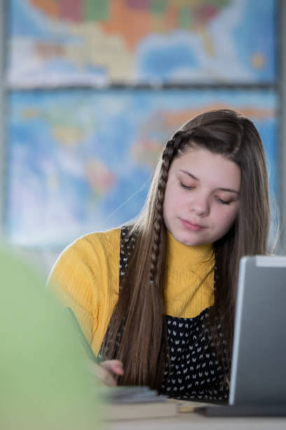 istock Teenage girl studying assignment in middle school classroom 1142494713