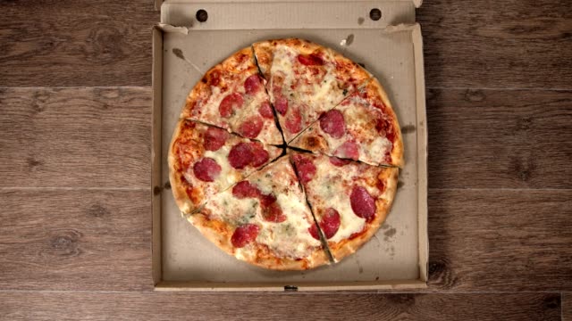 Delivery and opening a pizza box, different hands take pieces, stop motion animation