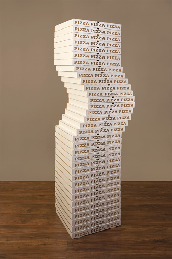 Large stack of pizza boxes represent fast food/obesity etc.