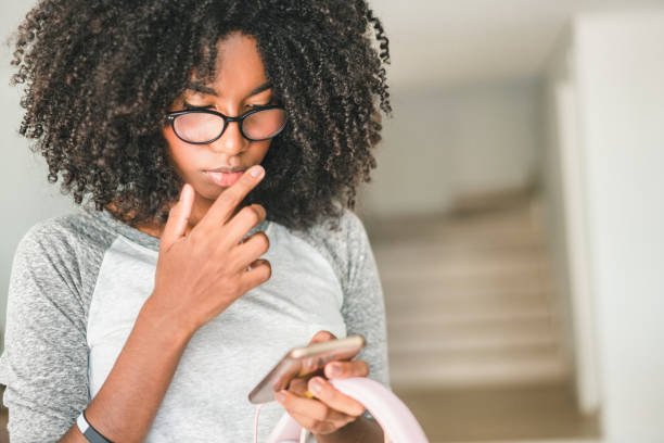 meninas do adolescente do afro que usam o smartphone em casa - addiction smart phone internet social networking - fotografias e filmes do acervo