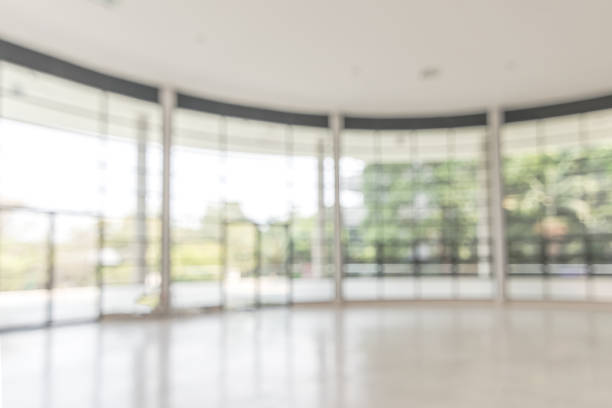 istock Blur background interior view looking out toward to empty office lobby and entrance doors and glass curtain wall 1142513483