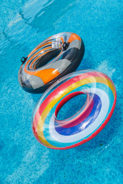 les activités nautiques gonflables cercles tuba flottent sur l’eau dans la piscine. concept, amusement, été perky et relaxation. - blue mattress vacations toy photos et images de collection