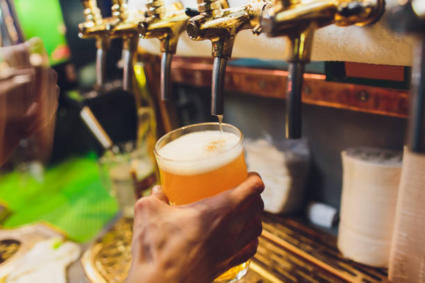istock Bartender pouring from tap fresh beer into the glass in pub. 1142516957