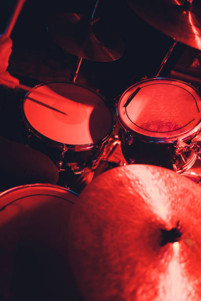 istock Drummer with a drumsticks in his hands playing on drum set on stage on the black background. 1142517036