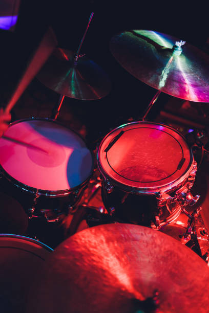 istock Drummer with a drumsticks in his hands playing on drum set on stage on the black background. 1142517040