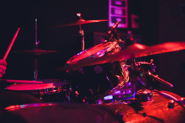 istock Drummer with a drumsticks in his hands playing on drum set on stage on the black background. 1142517042