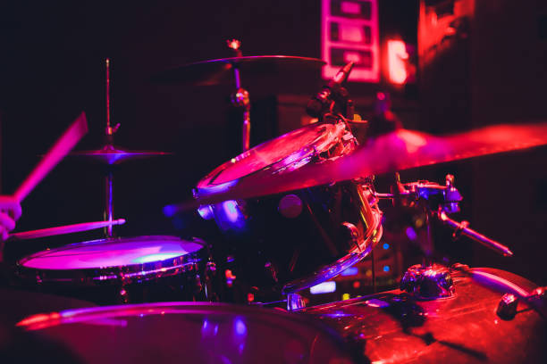 istock Drummer with a drumsticks in his hands playing on drum set on stage on the black background. 1142517048