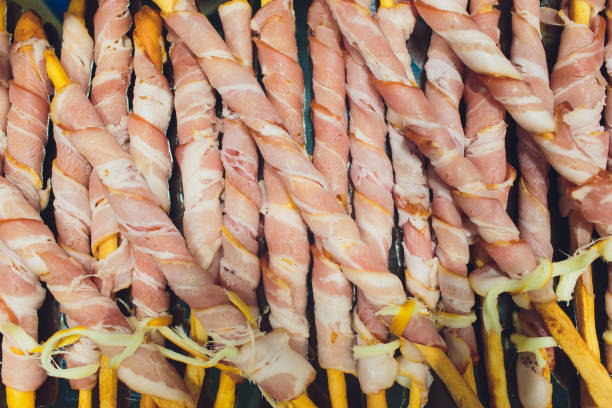 Twisted puff pastry sticks with bacon slices. Twisted puff pastry sticks with bacon slices twisted bacon stock pictures, royalty-free photos & images