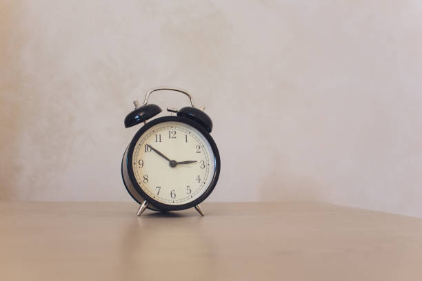 istock Vintage background with retro alarm clock on table. 1142517286